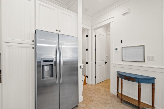 kitchen featuring light tile patterned floors, stainless steel refrigerator with ice dispenser, white cabinetry, and ornamental molding