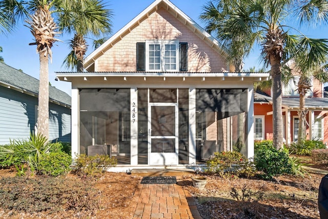 back of property featuring a sunroom and central AC