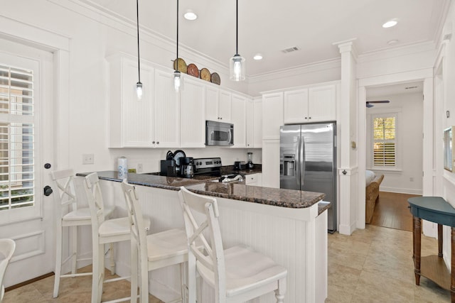 kitchen with white cabinetry, kitchen peninsula, stainless steel appliances, and pendant lighting