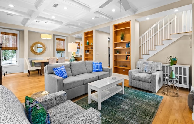 living room with wood-type flooring, beamed ceiling, built in features, ceiling fan, and coffered ceiling