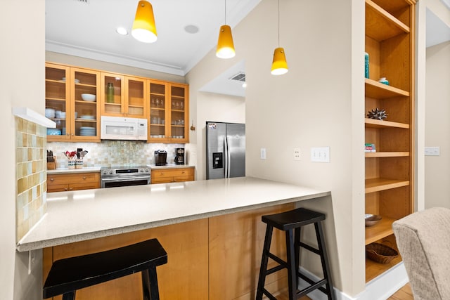 kitchen with hanging light fixtures, a breakfast bar, backsplash, and stainless steel appliances