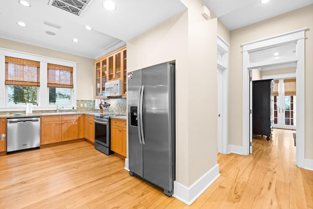 kitchen featuring light hardwood / wood-style floors, a wealth of natural light, and appliances with stainless steel finishes