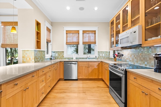 kitchen with decorative light fixtures, tasteful backsplash, sink, light stone countertops, and appliances with stainless steel finishes