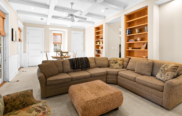 living room featuring ceiling fan, light colored carpet, beam ceiling, coffered ceiling, and built in features