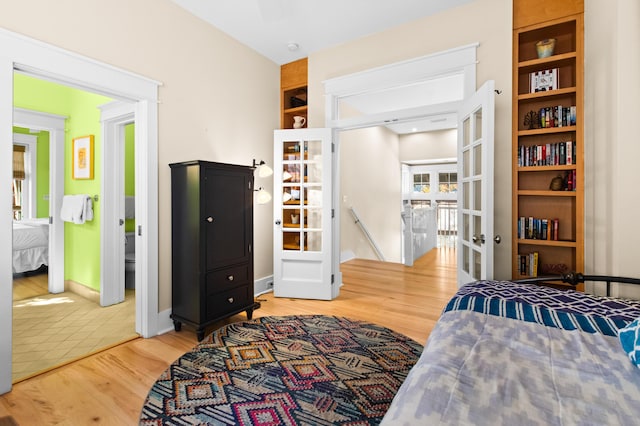 bedroom with wood-type flooring and connected bathroom