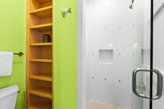 bathroom featuring walk in shower, tile patterned flooring, and toilet