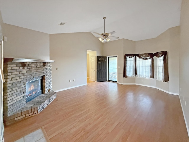 unfurnished living room with ceiling fan, lofted ceiling, a fireplace, and light hardwood / wood-style floors