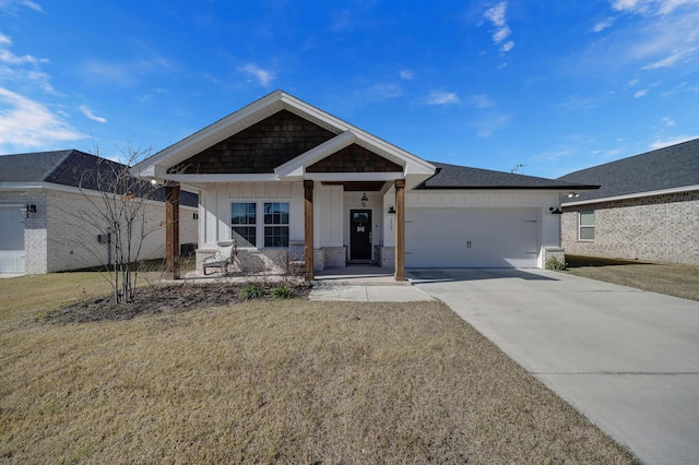 view of front of property featuring a porch, a front lawn, and a garage