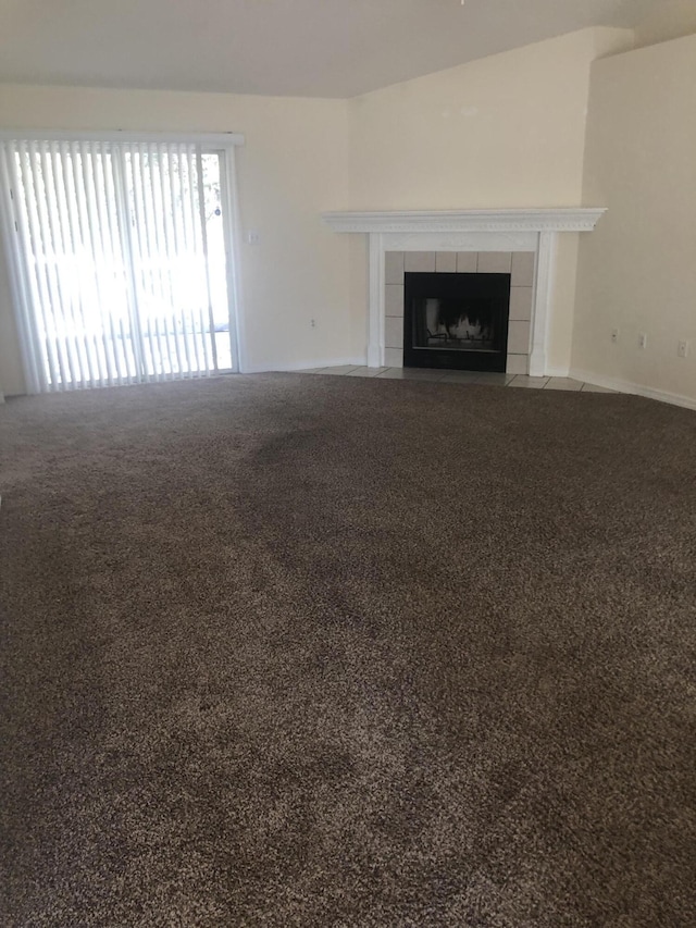 unfurnished living room with carpet and a tile fireplace