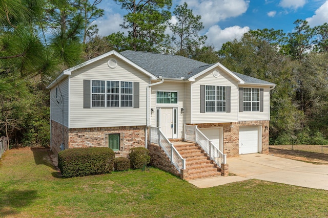 bi-level home featuring a front yard, concrete driveway, and brick siding