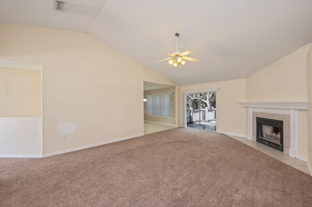 unfurnished living room featuring carpet floors, visible vents, a ceiling fan, vaulted ceiling, and a tile fireplace