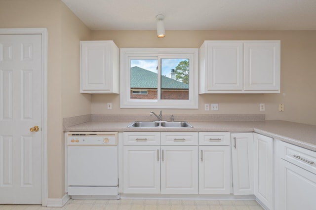 kitchen with white dishwasher, light countertops, light floors, white cabinetry, and a sink