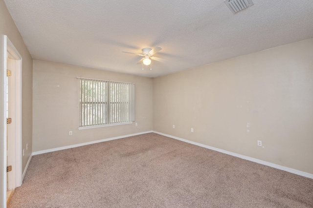 unfurnished room featuring a textured ceiling, baseboards, visible vents, and light colored carpet