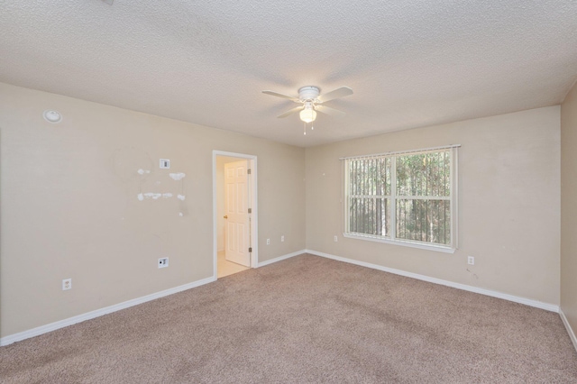 empty room with a ceiling fan, light carpet, a textured ceiling, and baseboards