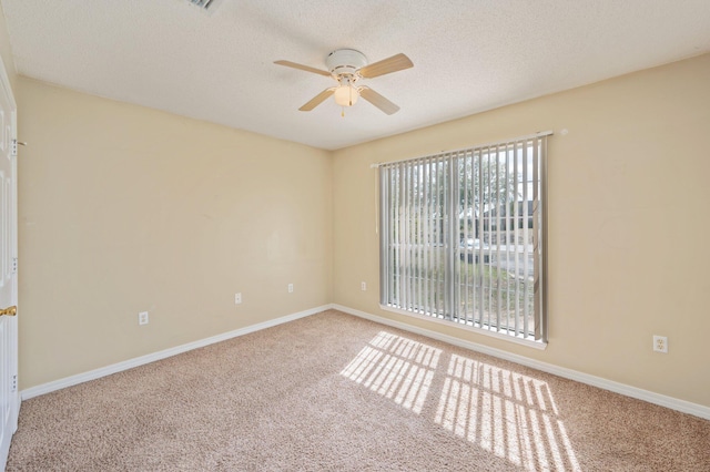 carpeted spare room featuring a ceiling fan, a textured ceiling, and baseboards