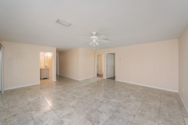 unfurnished room with baseboards, visible vents, and a ceiling fan