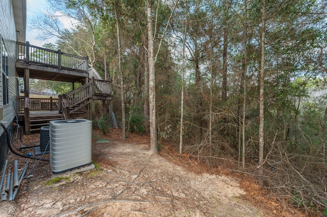 view of yard featuring stairs, central AC unit, and a wooden deck