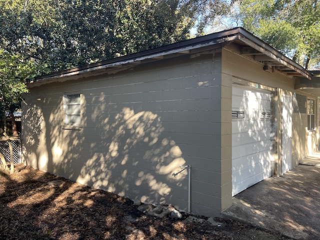 view of side of home featuring a garage and an outbuilding