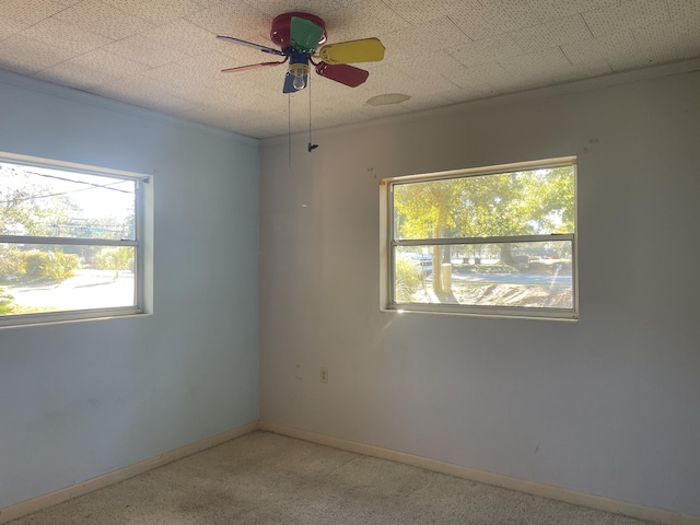 spare room with ceiling fan and crown molding