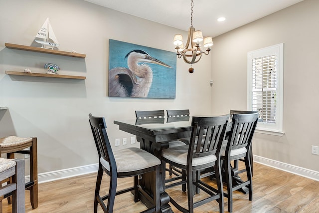 dining room with light wood-type flooring and an inviting chandelier