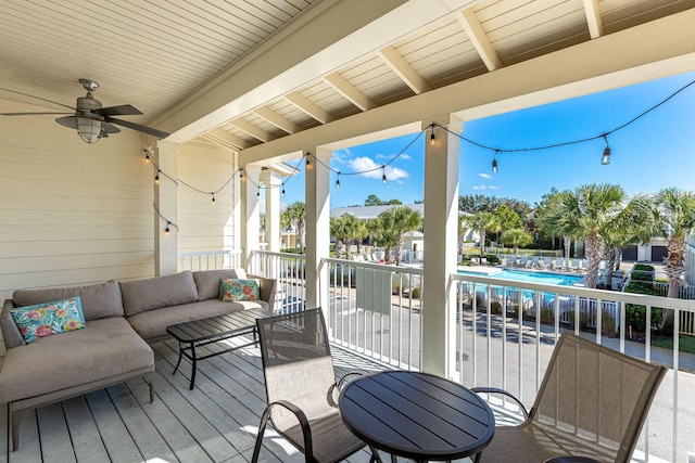 wooden terrace with an outdoor hangout area and a community pool