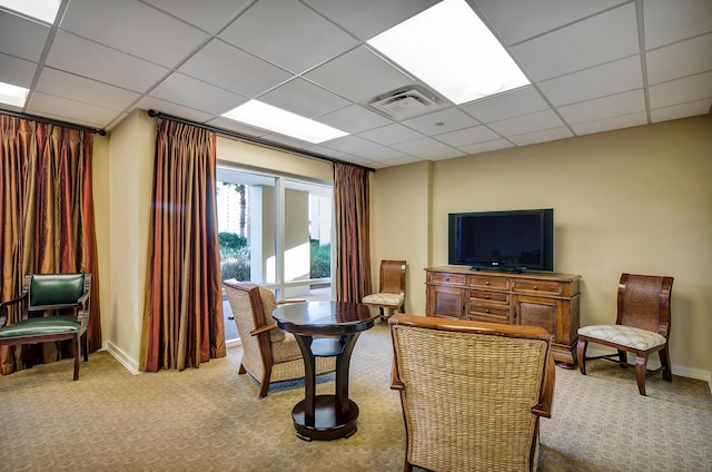 living area with light colored carpet and a paneled ceiling