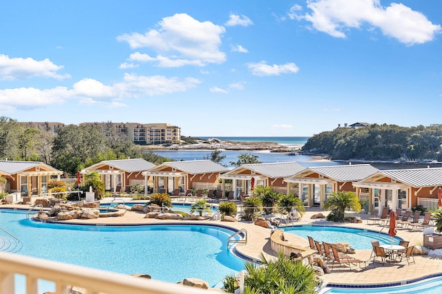 view of swimming pool featuring a water view and a patio