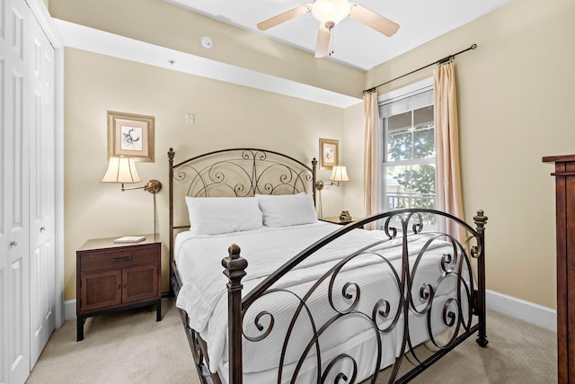 bedroom with ceiling fan, a closet, and light carpet