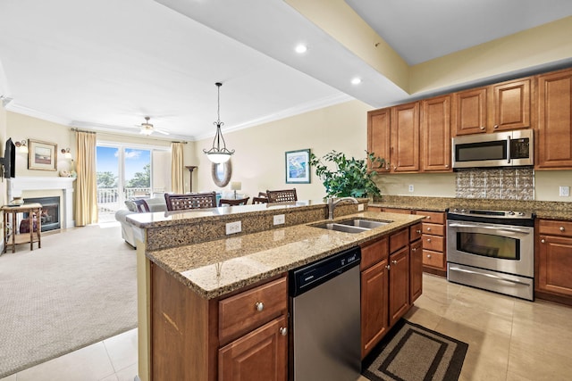 kitchen featuring appliances with stainless steel finishes, decorative backsplash, light colored carpet, pendant lighting, and sink