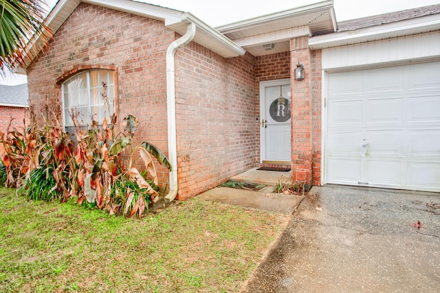 doorway to property featuring a yard and a garage