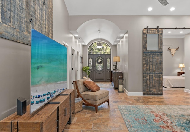 foyer entrance featuring lofted ceiling and a barn door