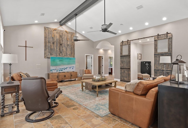 living room with ceiling fan, a barn door, high vaulted ceiling, and beam ceiling