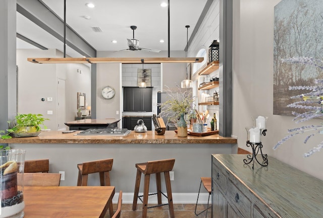 kitchen with hanging light fixtures, stainless steel gas cooktop, and ceiling fan