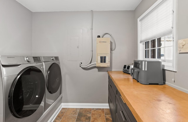 laundry area featuring independent washer and dryer, cabinets, and electric panel