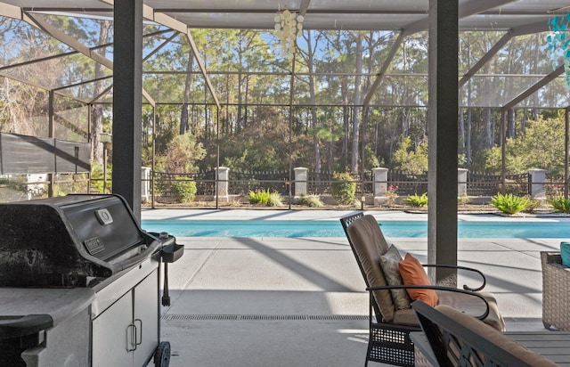 view of pool featuring grilling area, a patio, and glass enclosure