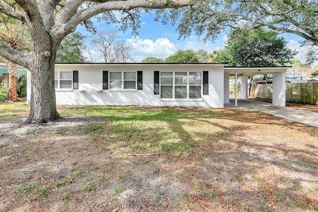 view of front of property featuring a front lawn and a carport