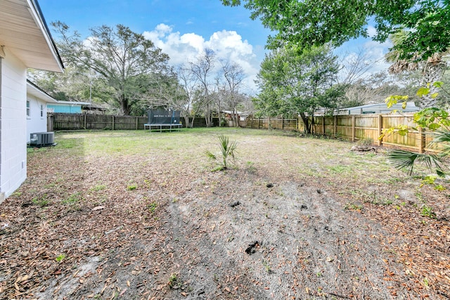 view of yard featuring central AC and a trampoline