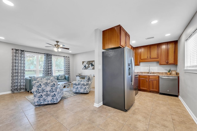 kitchen featuring ceiling fan, sink, appliances with stainless steel finishes, and light tile patterned floors