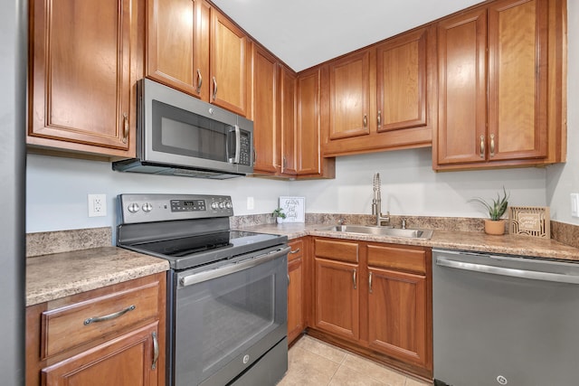 kitchen with light tile patterned floors, appliances with stainless steel finishes, and sink