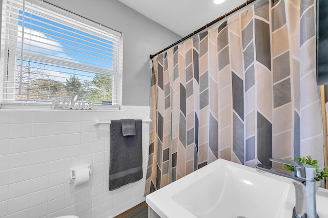 bathroom with sink and tile walls