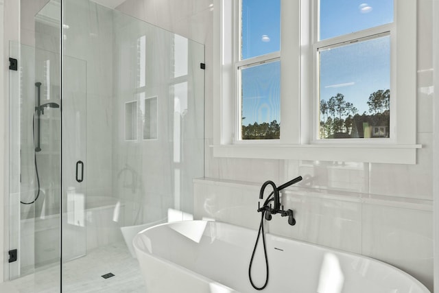 bathroom with a wealth of natural light and separate shower and tub