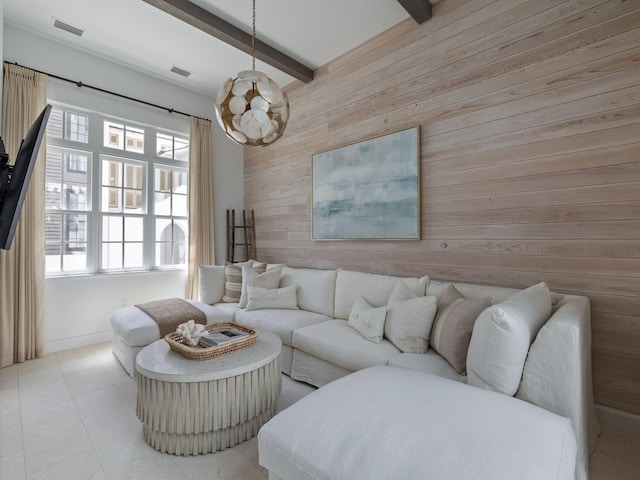 living room featuring a notable chandelier, a healthy amount of sunlight, beamed ceiling, and wooden walls