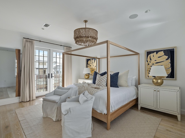 bedroom with a chandelier and light hardwood / wood-style flooring