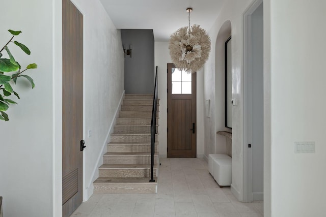 stairs with a notable chandelier