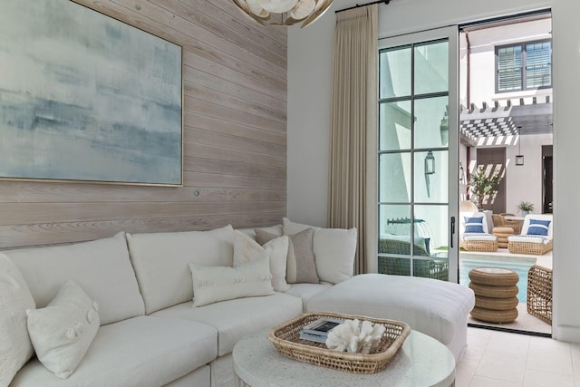 living room featuring light tile patterned flooring and wooden walls