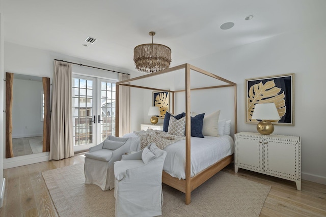 bedroom featuring light hardwood / wood-style floors and a notable chandelier