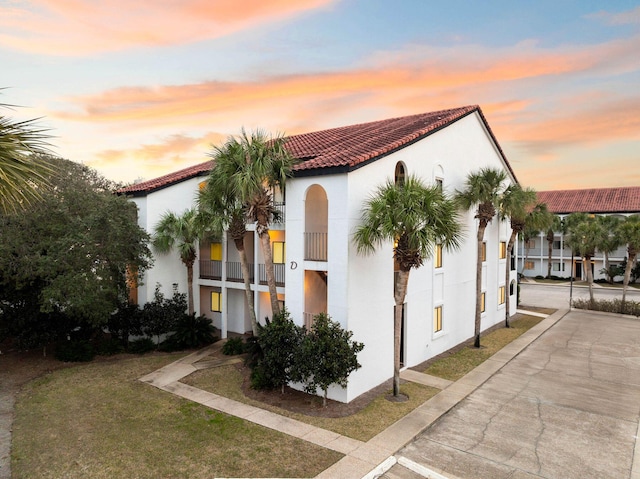 property exterior at dusk featuring a yard