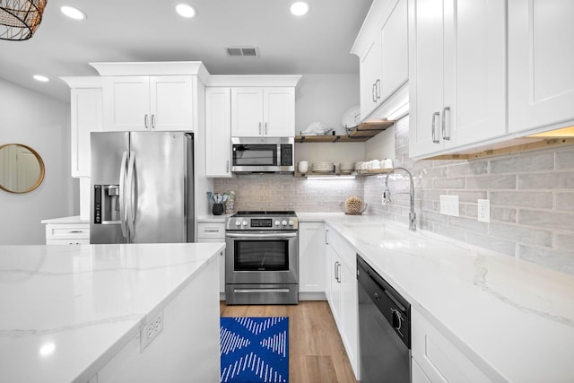 kitchen featuring appliances with stainless steel finishes, sink, white cabinetry, and light hardwood / wood-style floors