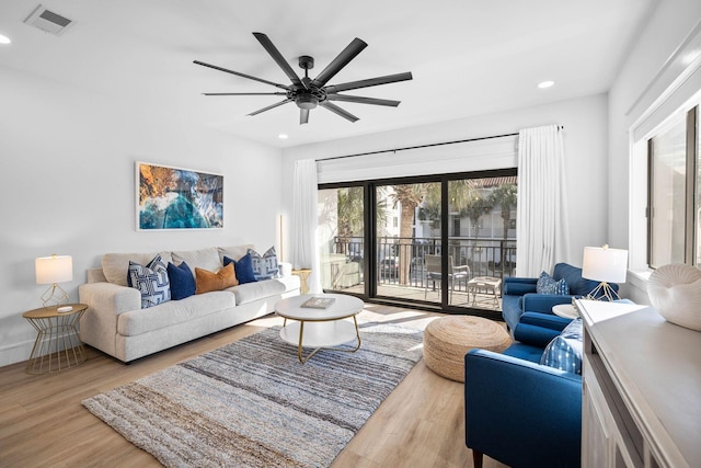 living room featuring ceiling fan and light hardwood / wood-style flooring