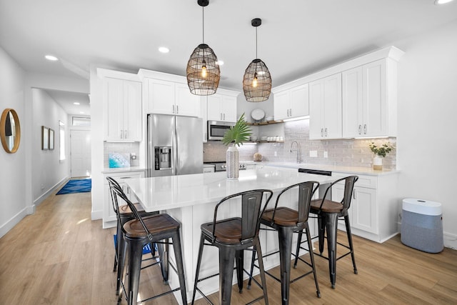 kitchen with stainless steel appliances, white cabinets, and a kitchen island